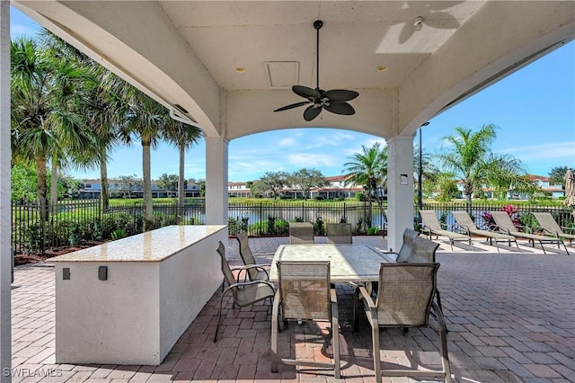 view of patio with ceiling fan and a water view