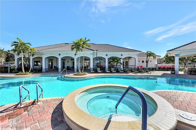 view of swimming pool with a patio and a hot tub