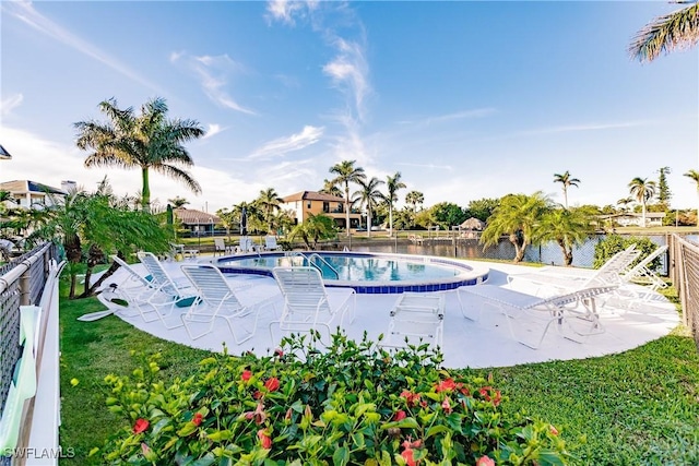 view of swimming pool with a yard, a water view, and a patio