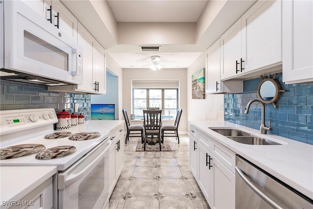 kitchen featuring white cabinets, white appliances, sink, and tasteful backsplash