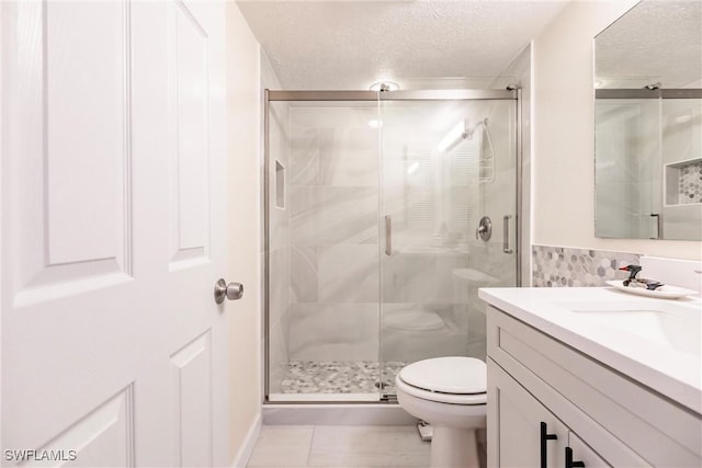 bathroom with toilet, a textured ceiling, tile patterned floors, and a shower with door