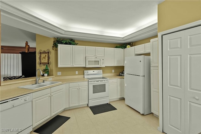 kitchen with a tray ceiling, sink, white cabinets, and white appliances