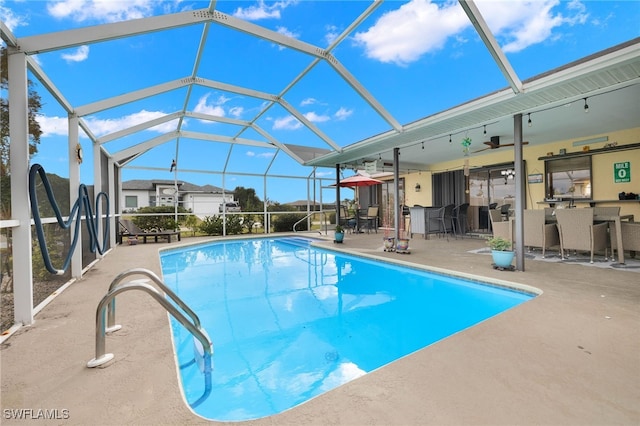 view of swimming pool with a lanai, ceiling fan, and a patio area