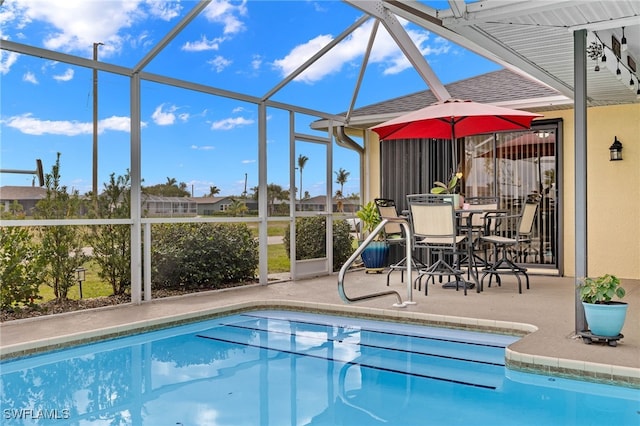 view of pool with a patio area and glass enclosure