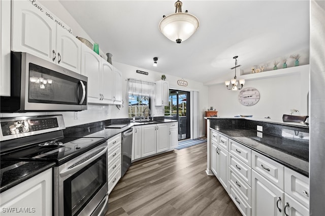 kitchen with stainless steel appliances, white cabinetry, hanging light fixtures, and sink