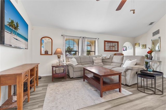 living room featuring lofted ceiling, ceiling fan, and light hardwood / wood-style flooring