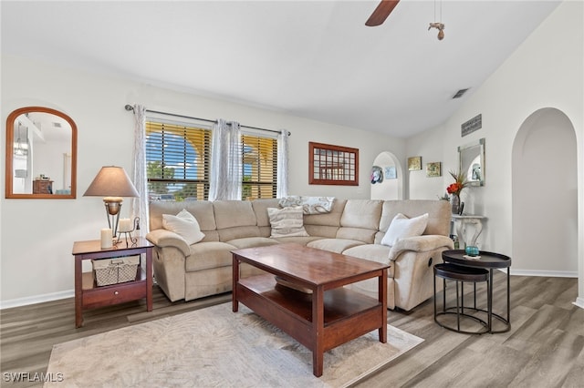 living room with wood-type flooring, vaulted ceiling, and ceiling fan