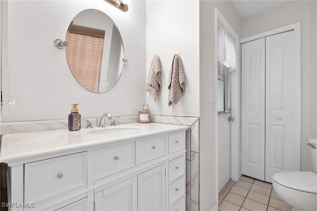 bathroom featuring vanity, tile patterned flooring, and toilet