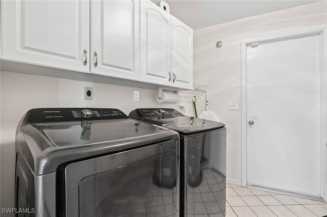 laundry area featuring cabinets, washing machine and dryer, and light tile patterned floors