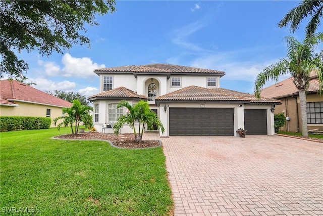 mediterranean / spanish-style home with an attached garage, a tiled roof, decorative driveway, stucco siding, and a front lawn