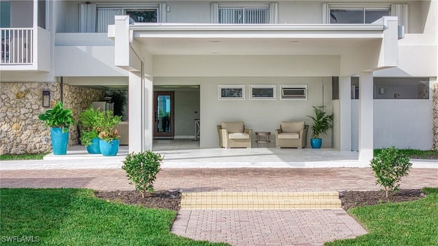 entrance to property with a balcony and a patio area