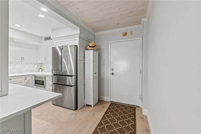 kitchen with white cabinets, backsplash, high end fridge, and light hardwood / wood-style flooring