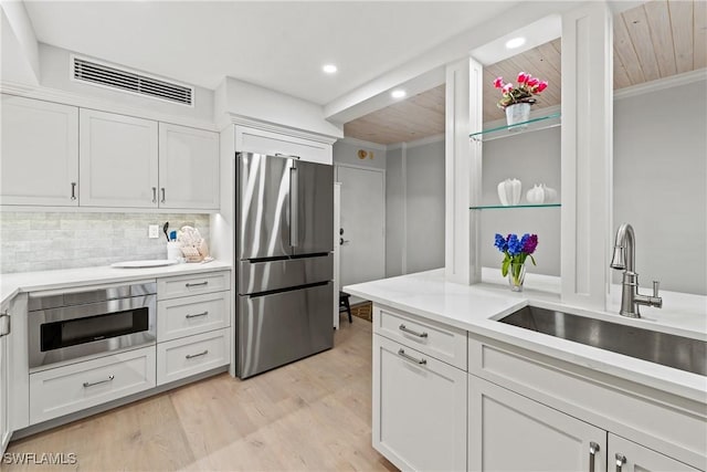 kitchen featuring white cabinets, stainless steel fridge, sink, and wood ceiling