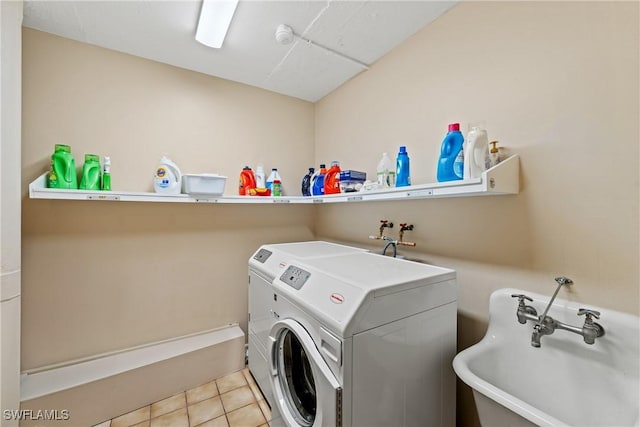 laundry area with sink, independent washer and dryer, and light tile patterned floors