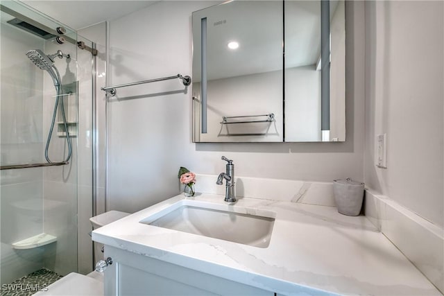 bathroom with toilet, walk in shower, and vanity