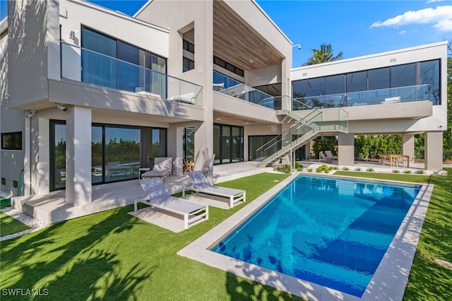 rear view of property featuring a patio area and a yard