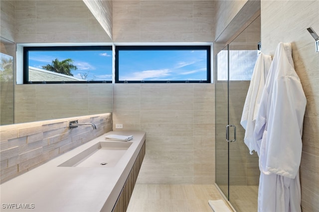 bathroom featuring plenty of natural light, tile patterned flooring, tile walls, and walk in shower