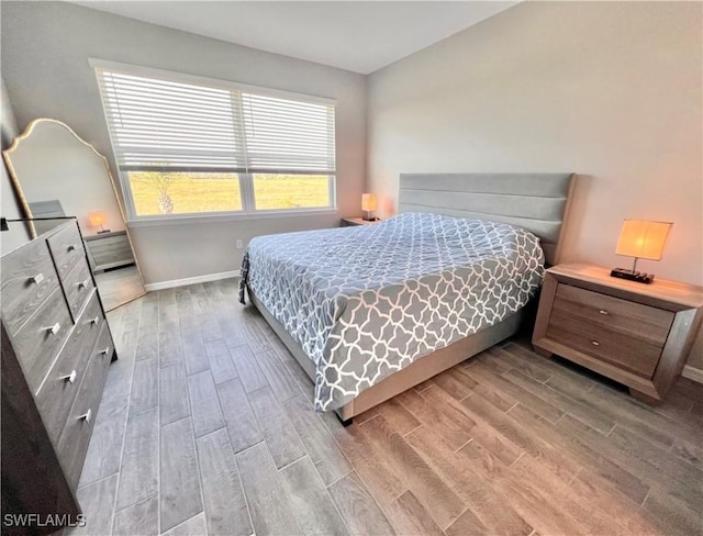 bedroom with multiple windows and light wood-type flooring