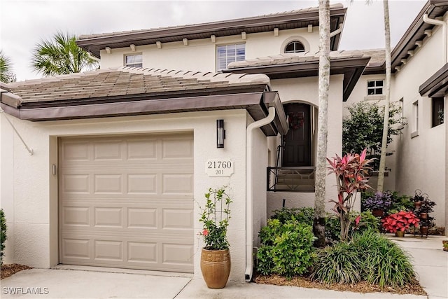 view of front of property featuring stucco siding, concrete driveway, and a tile roof