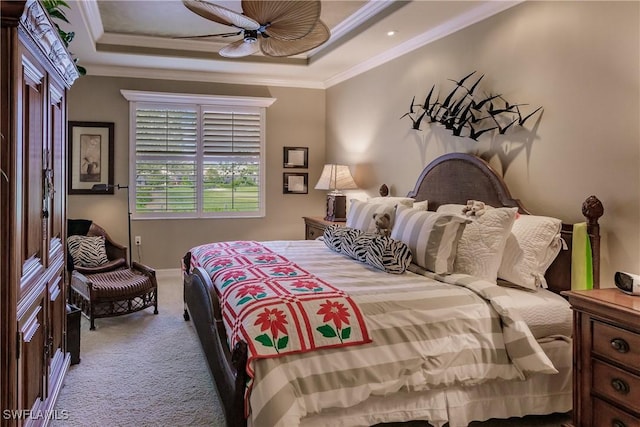 bedroom featuring ceiling fan, carpet flooring, a tray ceiling, and crown molding