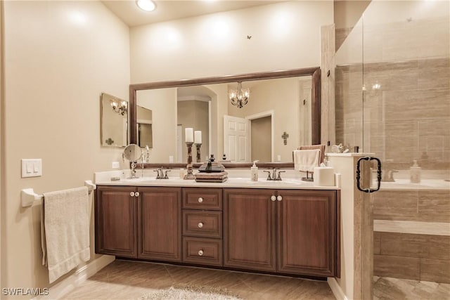 bathroom featuring tile patterned floors, a shower with door, a chandelier, and vanity