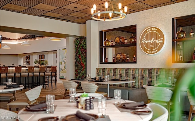 dining space featuring an inviting chandelier and brick wall