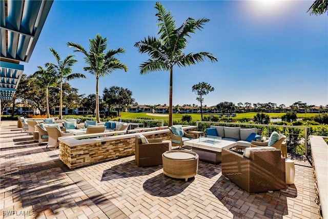 view of patio with an outdoor living space with a fire pit