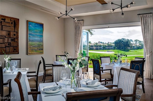 dining space featuring a notable chandelier, baseboards, and wood finished floors