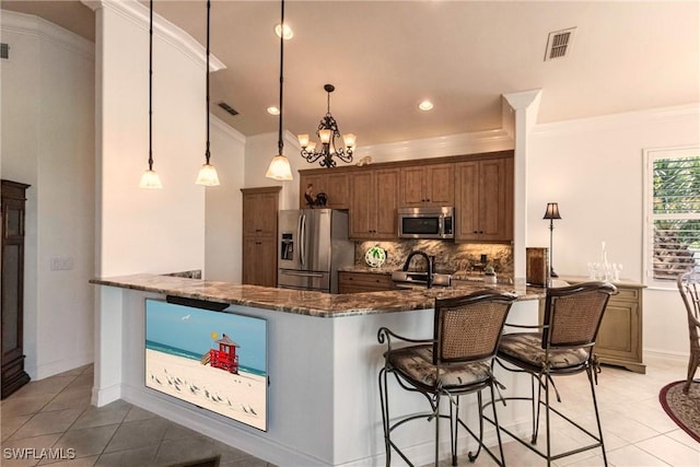 kitchen with visible vents, a peninsula, ornamental molding, stainless steel appliances, and tasteful backsplash