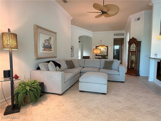 living room featuring visible vents, ornamental molding, arched walkways, light tile patterned floors, and ceiling fan