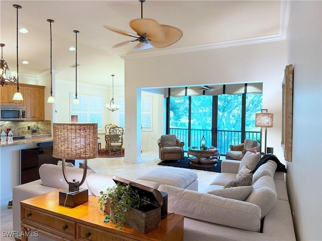living area with light tile patterned floors, recessed lighting, crown molding, and ceiling fan with notable chandelier