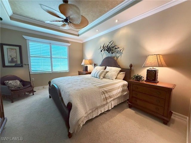 bedroom with light carpet, a ceiling fan, a tray ceiling, crown molding, and baseboards