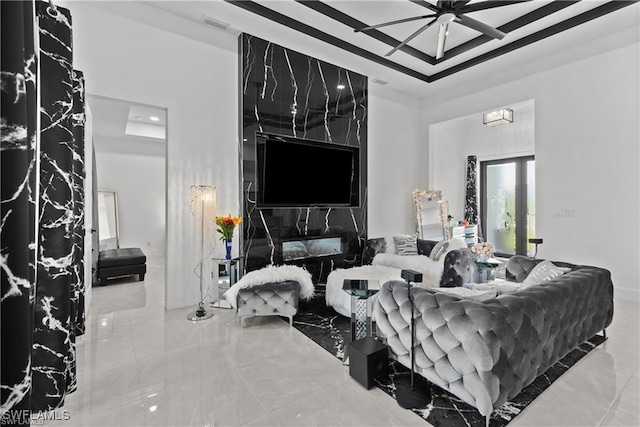 living room featuring a tray ceiling and ceiling fan