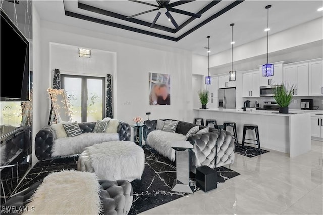 living room featuring a raised ceiling, a towering ceiling, and french doors