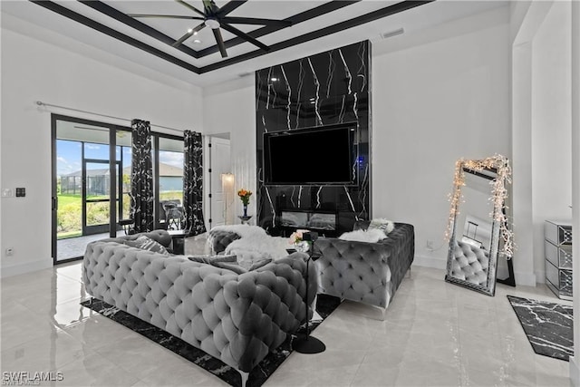 living room featuring ceiling fan and a high ceiling