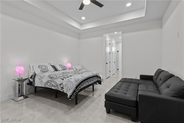 bedroom with a tray ceiling and ceiling fan