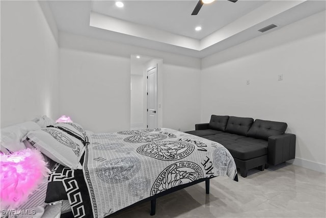 bedroom featuring a raised ceiling and ceiling fan