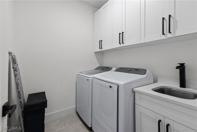 washroom with washer and clothes dryer, cabinets, light tile patterned floors, and sink