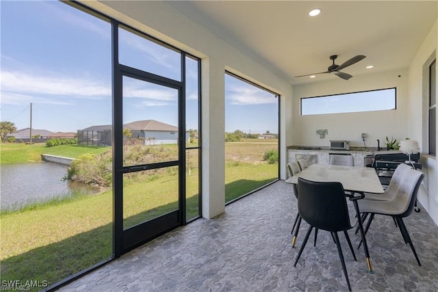 sunroom / solarium featuring ceiling fan