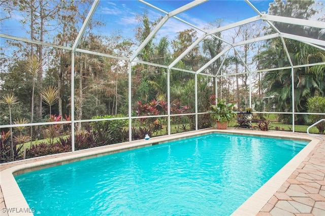 view of swimming pool featuring a lanai