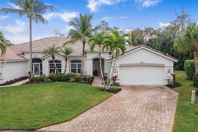 mediterranean / spanish home with a garage and a front lawn