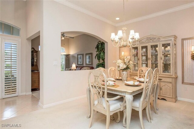 carpeted dining room with ceiling fan with notable chandelier and ornamental molding