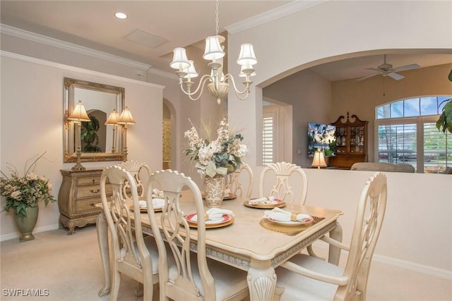 dining room featuring ceiling fan with notable chandelier, ornamental molding, and light colored carpet