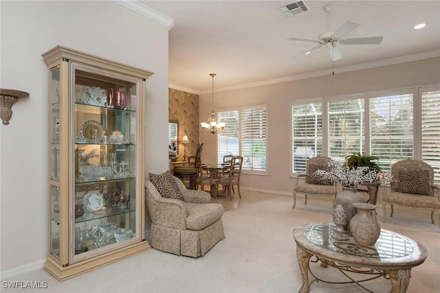 living room featuring crown molding, ceiling fan with notable chandelier, and carpet