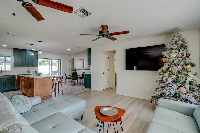 living room featuring ceiling fan and light hardwood / wood-style flooring