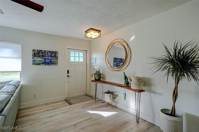 foyer with a textured ceiling and light hardwood / wood-style flooring