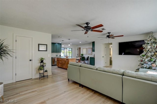 living room with light hardwood / wood-style floors and ceiling fan