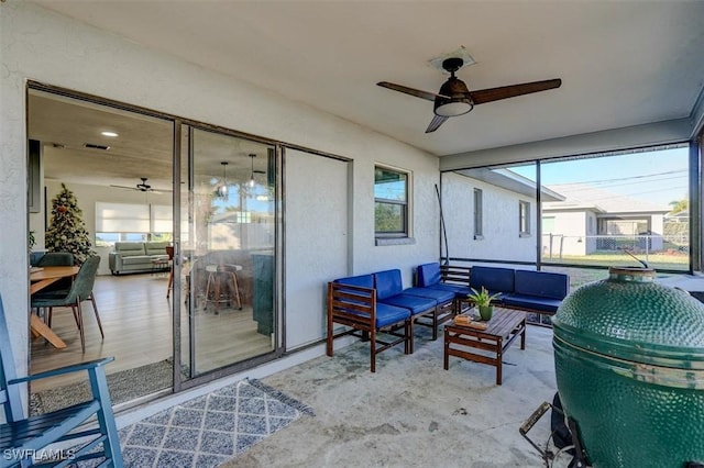 sunroom / solarium featuring ceiling fan