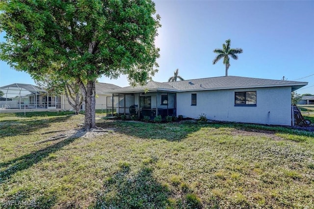 rear view of property with a sunroom and a yard