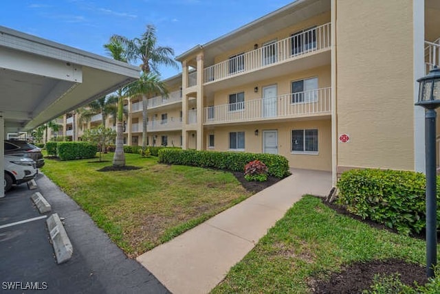 view of property's community featuring covered parking and a yard